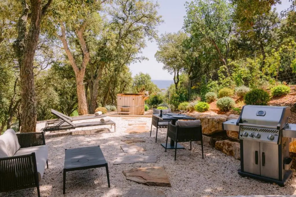 Terrasse de la Villa Mathilde au Domaine Louise à La Croix-Valmer avec barbecue, mobilier extérieur et transats au cœur de la nature